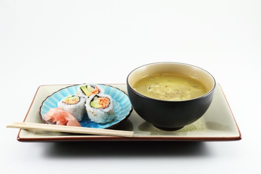 Fresh sushi served with a bowl of soup and chopsticks.