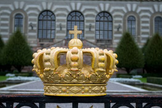 Fence with crown infront and Part of Royal Palace in Stckholm at background.
