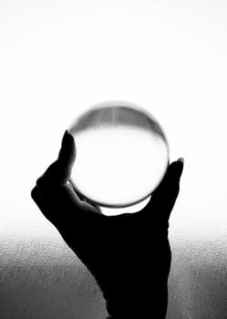 Crystal ball being held in hand in black and white