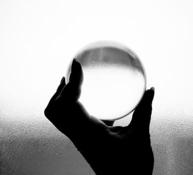 Crystal ball being held in hand in black and white