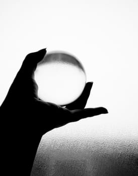 Crystal ball being held in hand in black and white