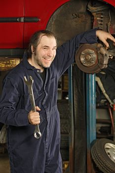 A crazy happy mechanic fixing brakes.