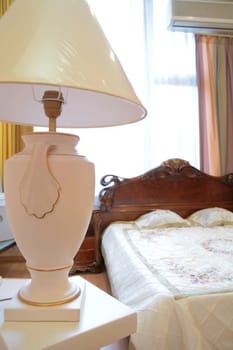 lamp in antique style with lampshade in luxurious bedroom