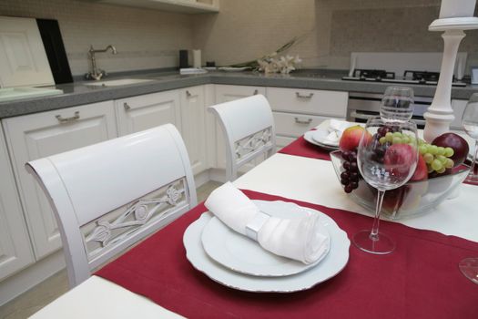 modern kitchen with white furniture in classical style and with served table