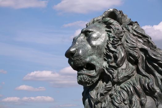 Fragment of the Cast-iron Sculpture on Background Blue Sky, Lion's Head