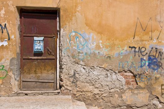 Old door and mailbox. Shattered plaster and a piece of masonry. Russian province. Outdoor Fragment. Closeup.