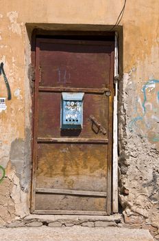 Old door and mailbox. Shattered plaster and a piece of masonry. Russian province. Outdoor Fragment. Closeup.