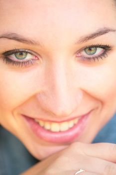 close-up portrait of the beautiful young smiling girl with green eye