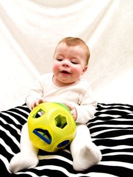 Cute little baby boy playing with toy