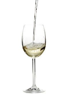 pouring white wine in a glass over a white background