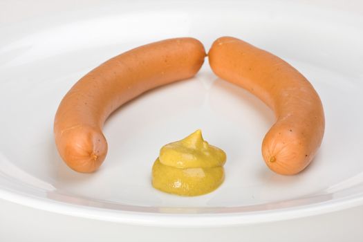 a pair of wieners on a white plate