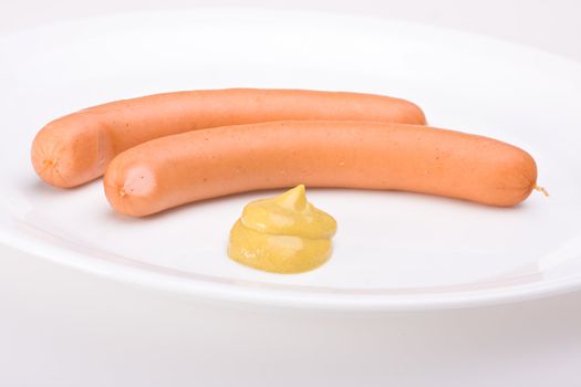 a pair of wieners on a white plate