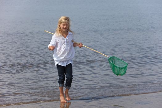 Young girl by the seashore with a fishing net