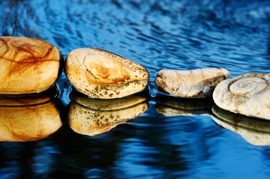 Four stones on dark blue background in water