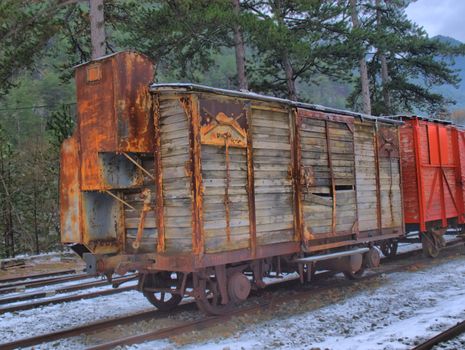 HDR image of ancient wooden train wagons at a snowy station