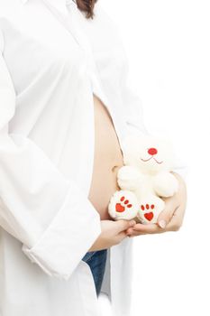 Woman hands holding pregnant belly with toy over white