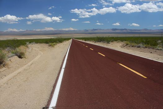 A road runs through the vast openness of the Mojave National Preserve in California.