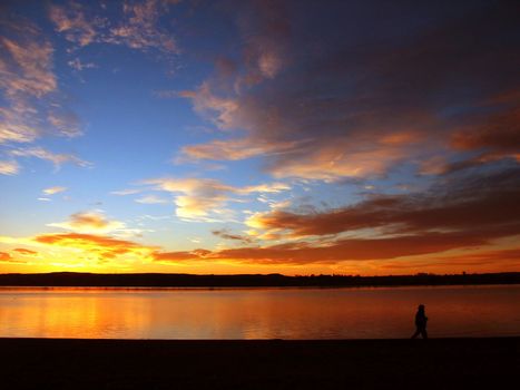 Person walking on a beach at sunrise in colorado