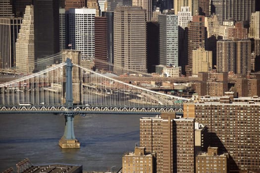 Aerial view of New York City's Manhattan Bridge with Brooklyn Bridge and Manhattan buildings in background.