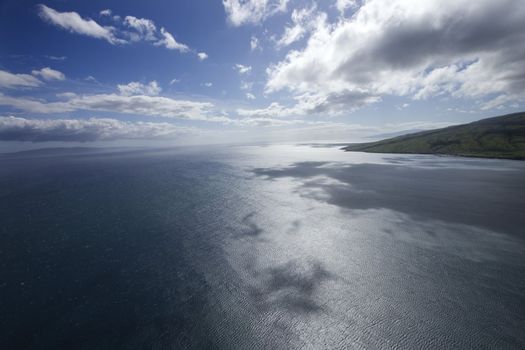Pacific ocean and sky with clouds and corner of island in Hawaii.