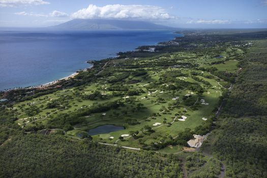 Aerial of golf course on Maui, Hawaii coastline with Pacific ocean.