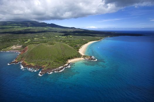 Aerial of Maui, Hawaii coastline with crater and cliffs and beach on Pacific ocean.