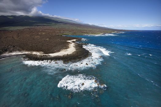 Aerial of Pacific ocean and Maui, Hawaii coast with lava rocks.