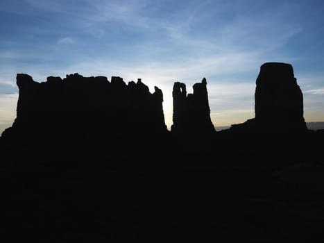 Sandstone mesas and buttes silhouetted in Monument Valley.