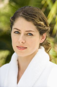 Attractive Caucasian mid-adult woman in white robe smiling.