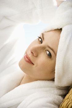 Caucasian mid-adult woman wearing towel on head looking at viewer.