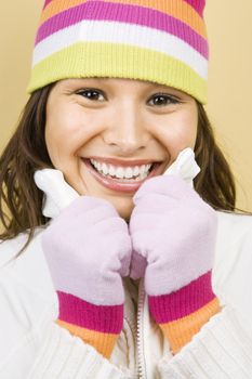 Young adult Caucasian woman wearing winter hat and gloves and smiling at viewer.