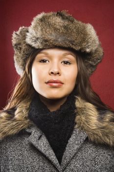 Young adult Caucasian woman wearing fur hat looking at viewer.