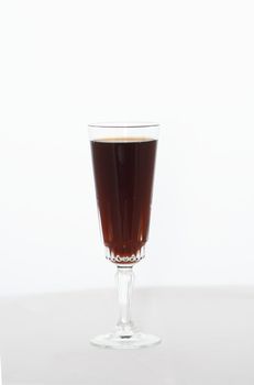 a glass of red wine against a light background