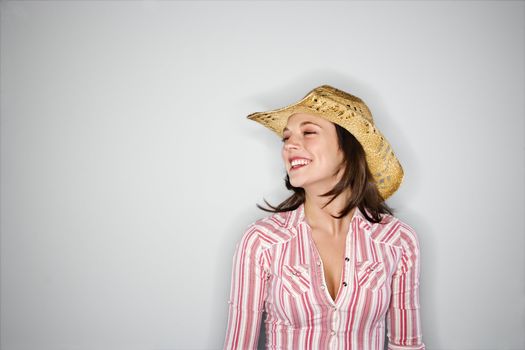 Young Caucasian woman wearing cowboy hat smiling.