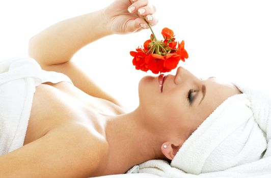 lovely woman in spa smelling red flower