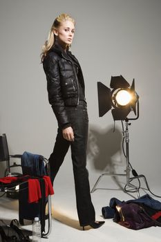 Pretty young Caucasian blonde woman standing with studio lights.