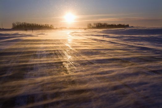 Ice covered road with sun rising in distance.