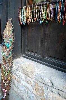 row of colorful bracelets and necklaces with different types of stones and woods