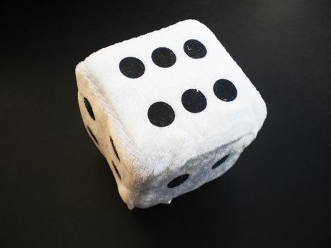 one white die isolated on black background 