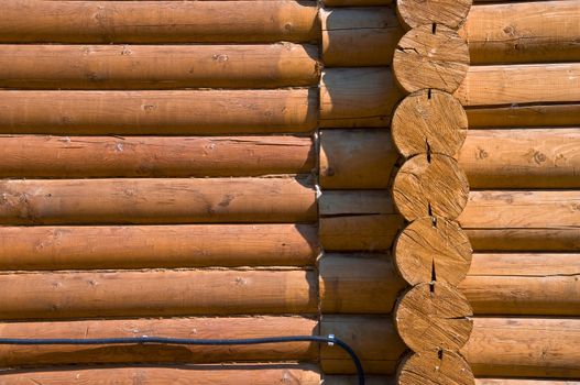 Detail of the wall section log house. Close-up. Stained wood and smooth sawn timber. Pine