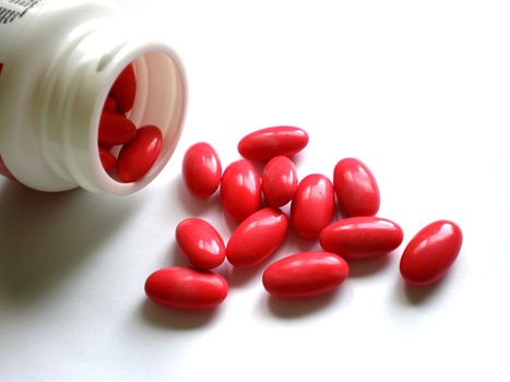 bottle and pile of pills isolated on white background