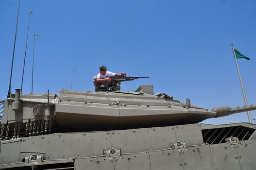 A boy playing with a machine gun mounted on top of the turret.