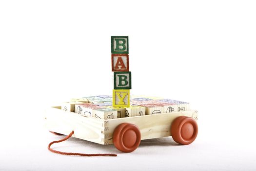 kids wooden alphabet letter set in a wooden box with wheels with cubes spelling the word baby