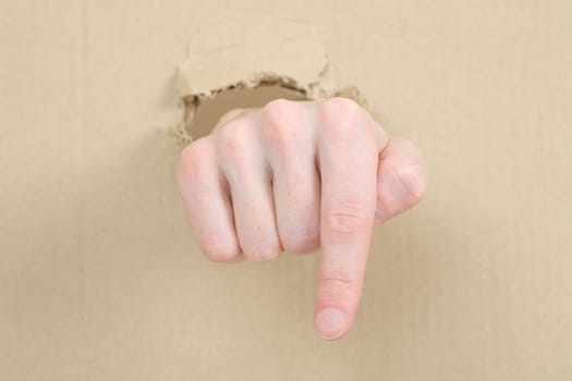 Gesture male hand through from hole in cardboard