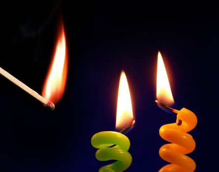 Candle and match on a black background                               