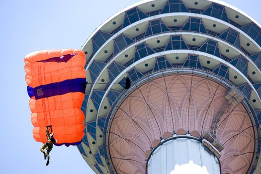 Image of a daring base jumper in action. In the background is the KL Tower, at Kuala Lumpur, Malaysia.