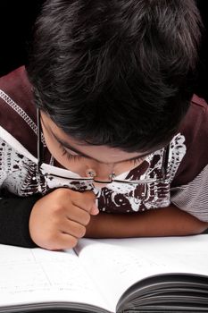 A genius little kid studying with concentration.