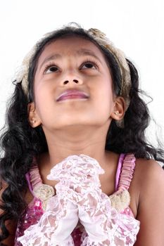 A portrait of a cute Indian girl praying desperately to god, on white studio background.
