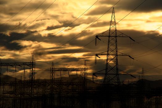 A view of a stormy sky at dawn, near a power station.