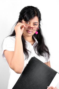 A young Indian businesswoman holding a file containing her resume, on white studio background.